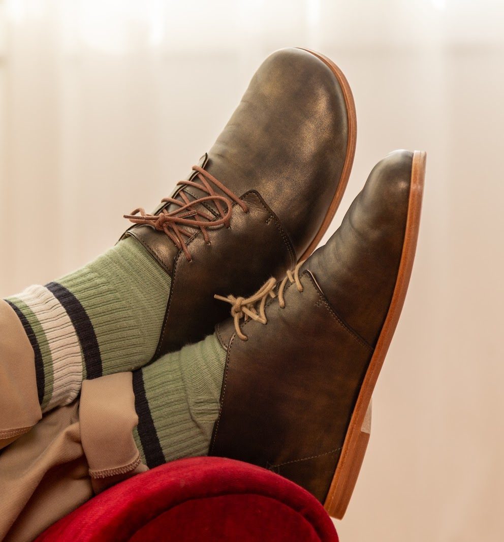 marleys boots and green dance socks up on a red sofa